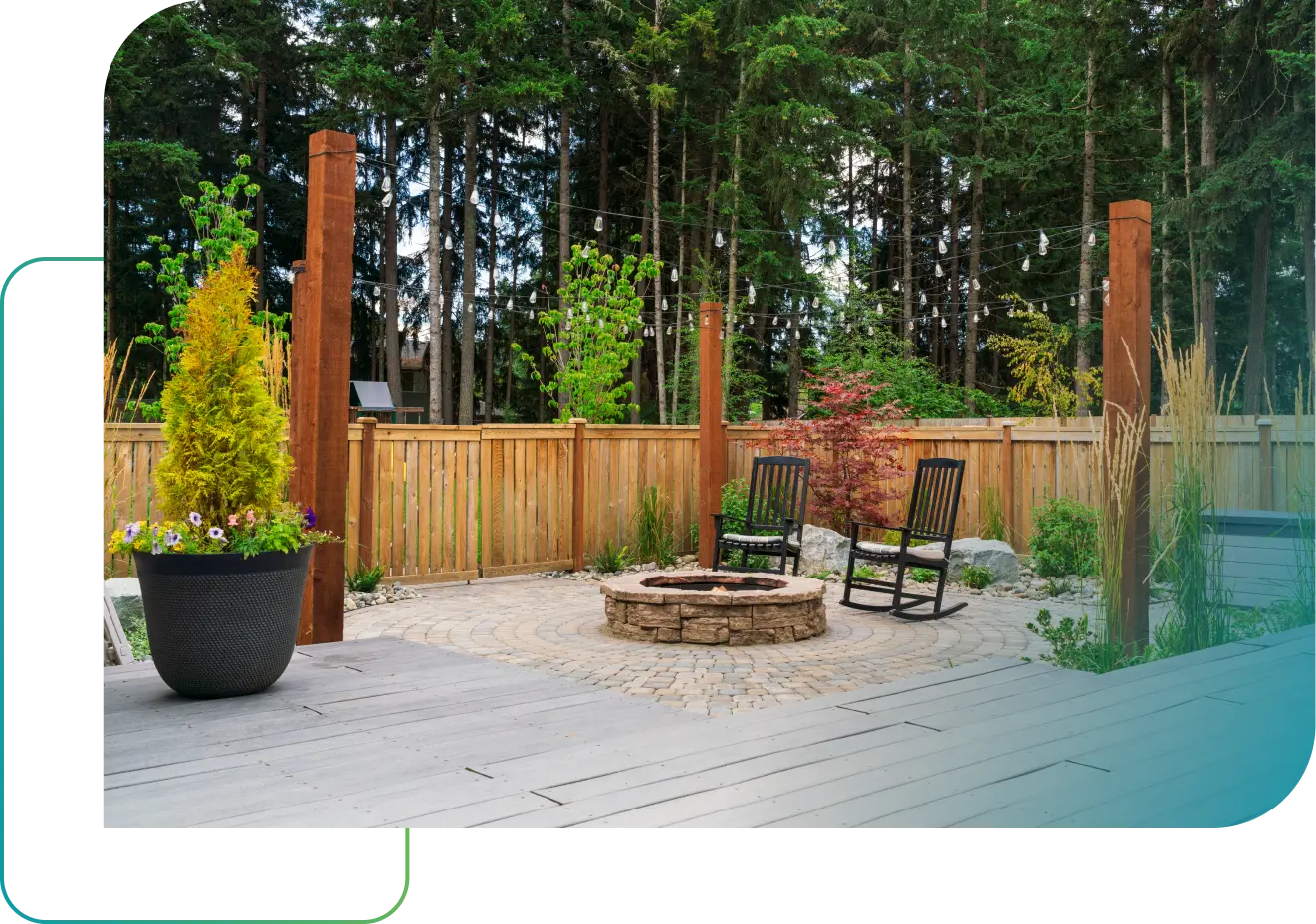 Backyard fire pit area with stone patio, wood decking, and custom landscaping by True Design Landscape